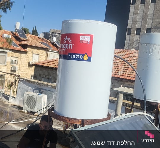 התקנת דוד שמש על גג עם שני אנשים עובדים